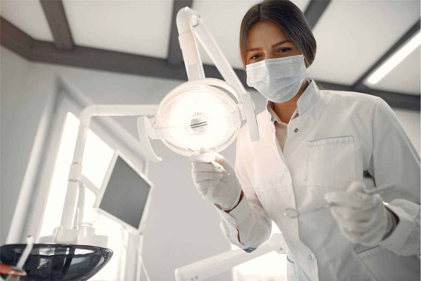 mulher dentista observando a câmera nos tratamentos odontológicos